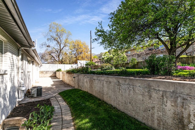 view of yard featuring central air condition unit, a patio area, and a fenced backyard