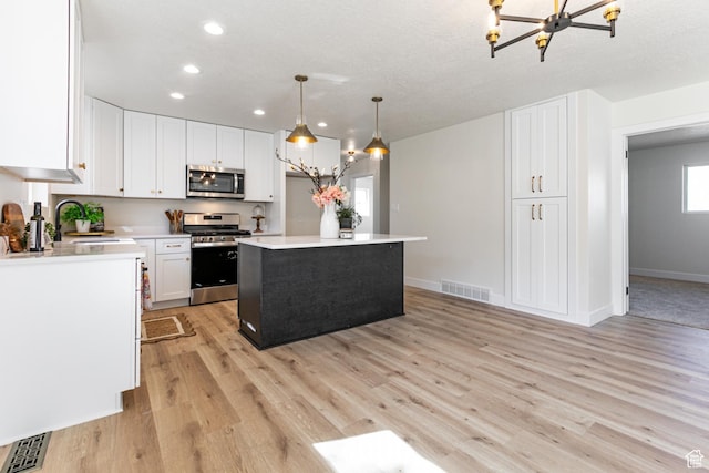 kitchen featuring white cabinets, stainless steel appliances, a sink, visible vents, and recessed lighting