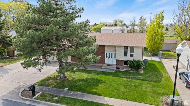 1971 N 3060 W, Clinton, UT 84015 - raised ranch featuring concrete driveway, a front lawn, fence, brick siding, and roof with shingles