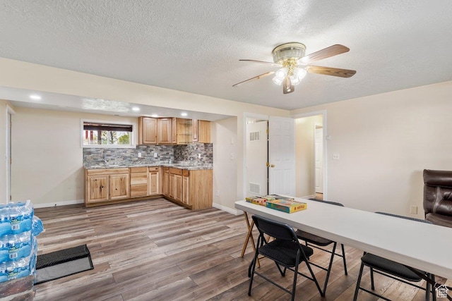 1971 N 3060 W, Clinton, UT 84015 - kitchen featuring decorative backsplash, baseboards, a textured ceiling, and light wood finished floors