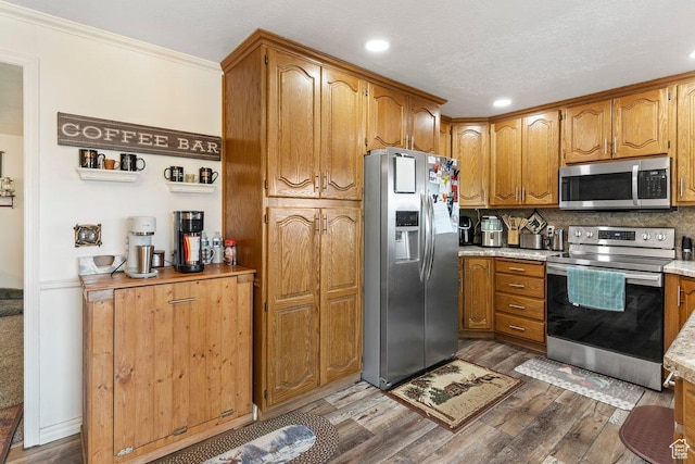 1971 N 3060 W, Clinton, UT 84015 - kitchen featuring brown cabinets, stainless steel appliances, light countertops, wood finished floors, and ornamental molding