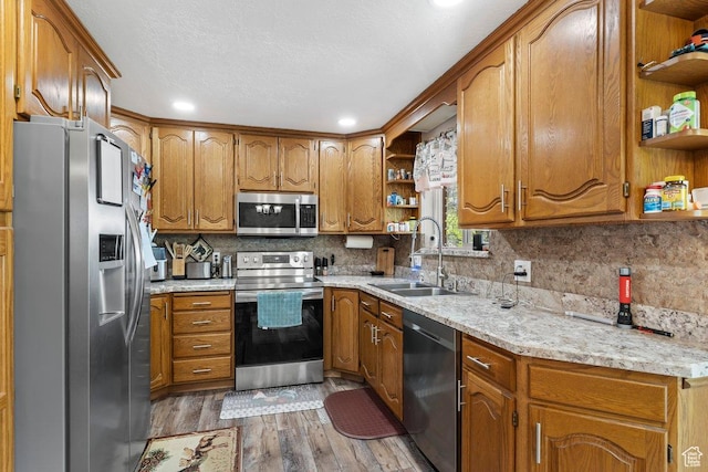 1971 N 3060 W, Clinton, UT 84015 - kitchen with open shelves, wood finished floors, a sink, brown cabinetry, and appliances with stainless steel finishes
