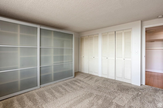 521 E 5th Ave Unit 302, Salt Lake City, UT 84103 - unfurnished bedroom featuring multiple closets, a textured ceiling, and carpet