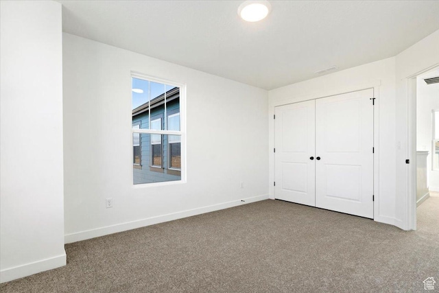unfurnished bedroom with carpet, baseboards, and a closet