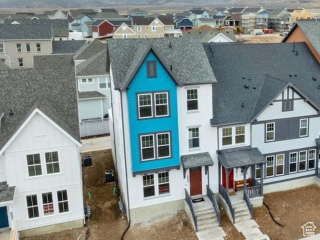 multi unit property with a residential view, a shingled roof, and board and batten siding