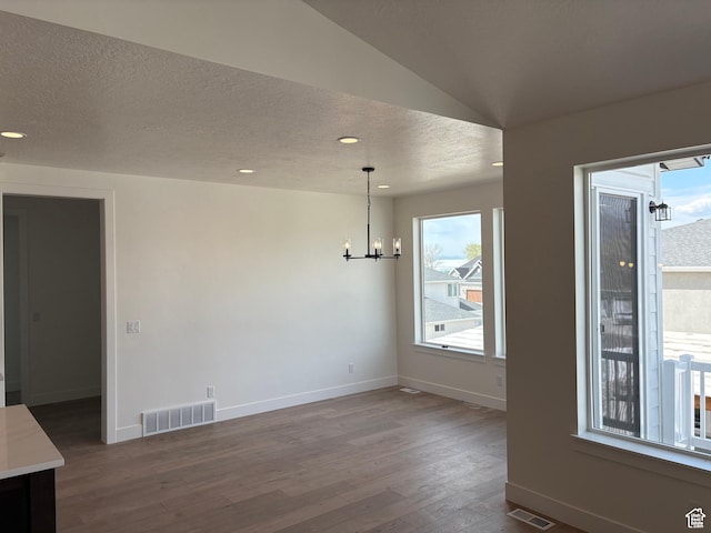 unfurnished dining area with dark wood-style floors, baseboards, a chandelier, and visible vents