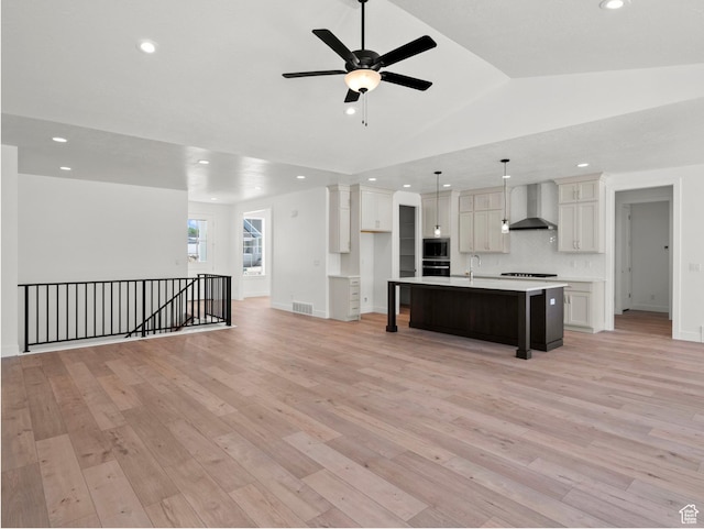 1256 W 800 S # 12, Spanish Fork, UT 84660 - kitchen with wall chimney exhaust hood, black oven, light wood-style flooring, stainless steel microwave, and a ceiling fan