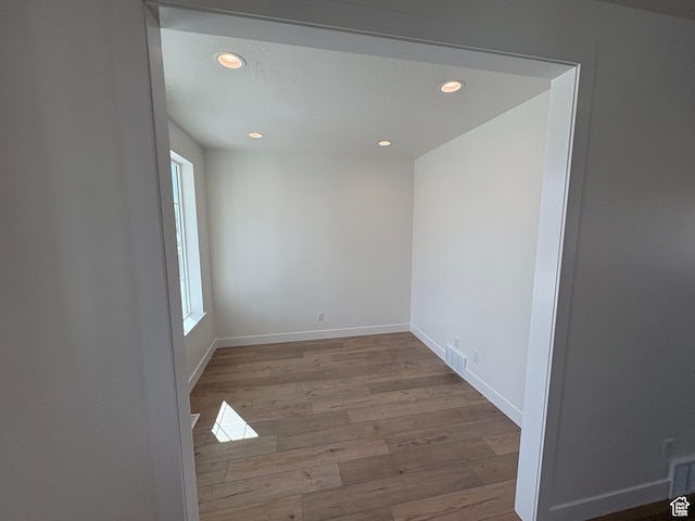 empty room featuring visible vents, wood finished floors, and recessed lighting
