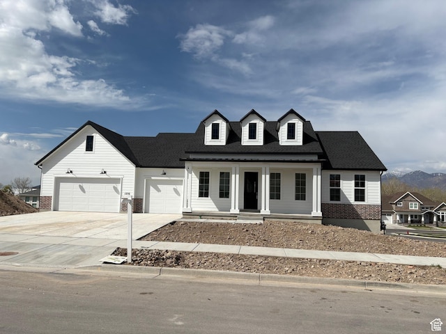 view of front of property with an attached garage, a porch, brick siding, and concrete driveway