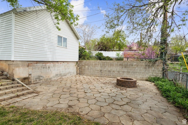 view of patio with a fire pit and fence