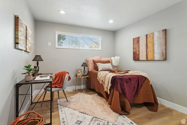 bedroom featuring wood finished floors, baseboards, and recessed lighting