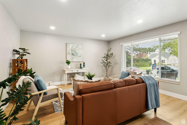living room featuring light wood-type flooring, baseboards, and recessed lighting