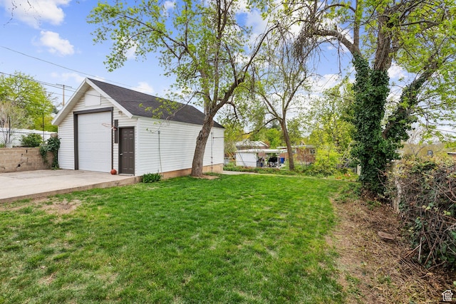 view of yard featuring concrete driveway, an outdoor structure, fence, and a garage