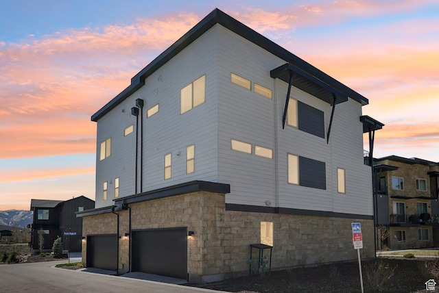 1152 Gambel Oak Way, Park City, UT 84098 - property exterior at dusk featuring an attached garage and stone siding