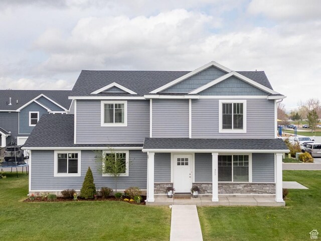 455 W 1140 N, Logan, UT 84341 - view of front of home with a front lawn, roof with shingles, stone siding, and a trampoline