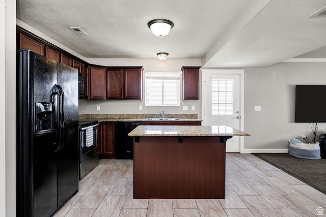 455 W 1140 N, Logan, UT 84341 - kitchen with a sink, visible vents, light stone counters, a kitchen island, and black appliances