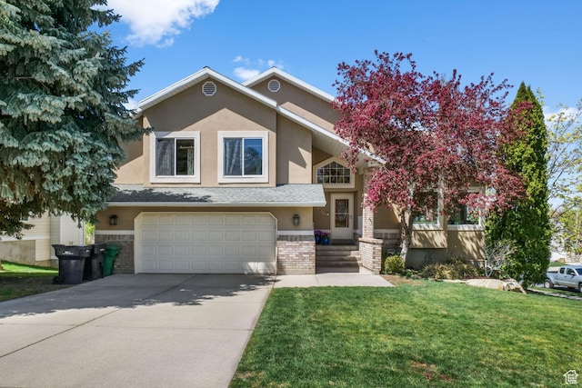 view of front of property with a front lawn, driveway, a garage, brick siding, and stucco siding