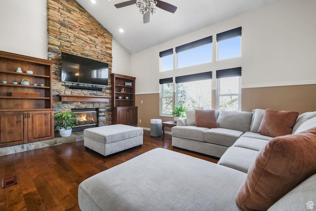 living room featuring visible vents, dark wood-type flooring, a fireplace, high vaulted ceiling, and ceiling fan