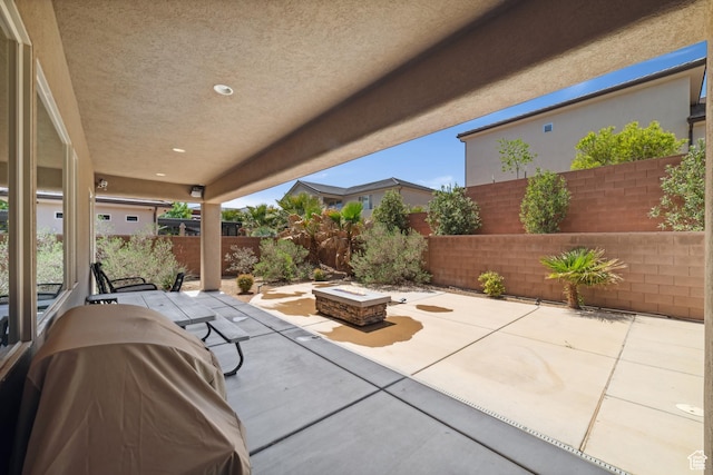 view of patio featuring a fenced backyard and an outdoor fire pit