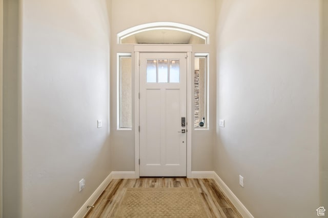 foyer entrance featuring baseboards and light wood finished floors