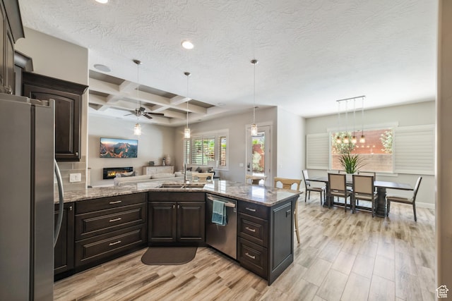kitchen with light wood-style floors, appliances with stainless steel finishes, a ceiling fan, and a sink
