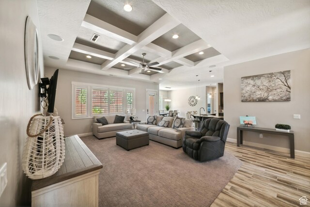 living room with beam ceiling, light wood-type flooring, baseboards, coffered ceiling, and a ceiling fan