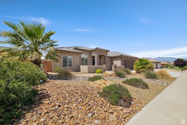 view of front of home featuring stucco siding, an attached garage, a mountain view, and a tile roof