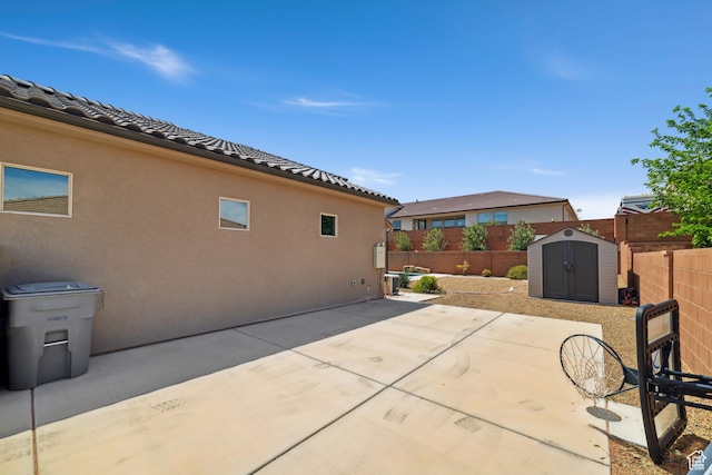 view of patio with a storage shed, an outbuilding, and a fenced backyard