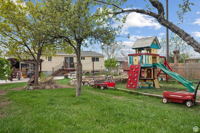 view of jungle gym with a lawn and fence