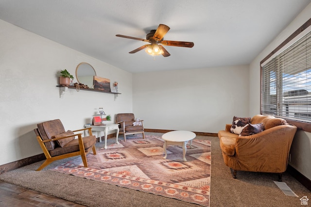 living room with ceiling fan, baseboards, wood finished floors, and visible vents