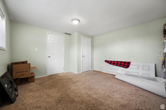 unfurnished room featuring baseboards, visible vents, and carpet