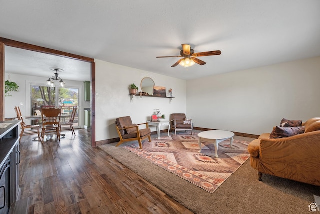 living area featuring wood finished floors, baseboards, and ceiling fan