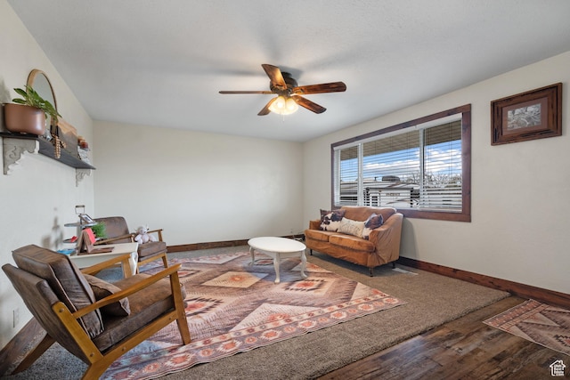 living room featuring baseboards, a ceiling fan, and wood finished floors