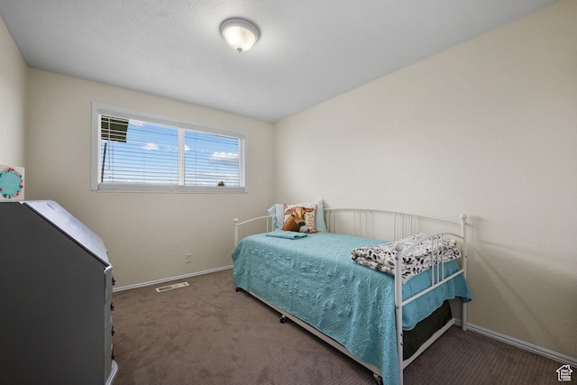 carpeted bedroom featuring baseboards and visible vents