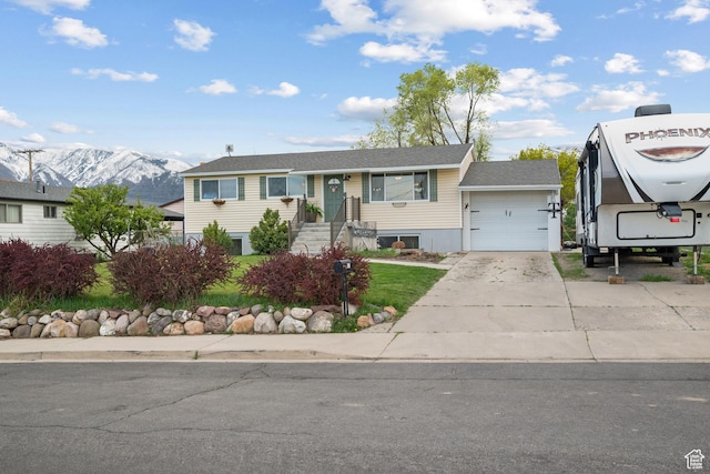 single story home featuring a garage, a mountain view, and concrete driveway