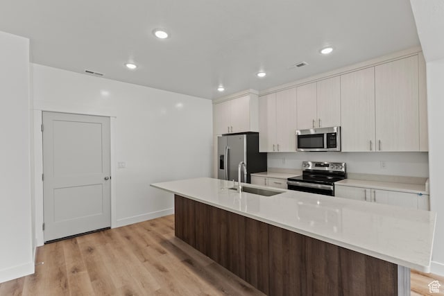 3374 S 1010 W, Nibley, UT 84321 - kitchen featuring a sink, light wood-type flooring, visible vents, an island with sink, and appliances with stainless steel finishes
