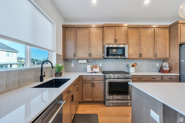 1167 S 1275 W, Clearfield, UT 84015 - kitchen with a sink, light wood-style floors, brown cabinets, light stone counters, and appliances with stainless steel finishes