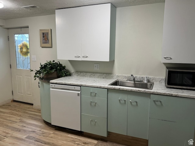 75 S Cooley St W, Grantsville, UT 84029 - kitchen with green cabinetry, dishwasher, a sink, stainless steel microwave, and light wood-type flooring