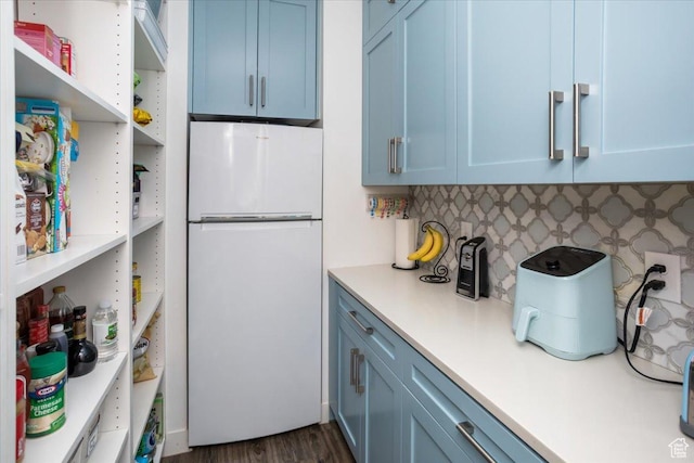 364 W Clark Cir, Farmington, UT 84025 - kitchen with freestanding refrigerator, blue cabinetry, light countertops, and backsplash