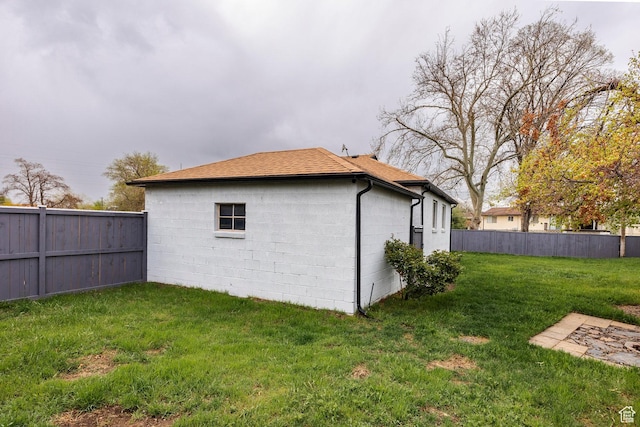 1425 W Riverside Cir, Salt Lake City, UT 84116 - view of side of property with a lawn, fence, concrete block siding, and a shingled roof