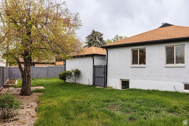 1425 W Riverside Cir, Salt Lake City, UT 84116 - view of home's exterior featuring a fenced backyard, a shingled roof, and a lawn