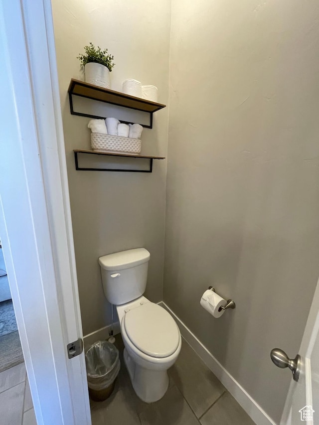 bathroom featuring toilet, tile patterned floors, and baseboards