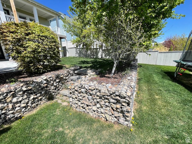 view of yard with a fenced backyard and a trampoline