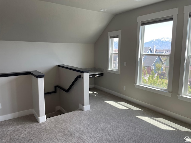 bonus room with lofted ceiling, a wealth of natural light, and carpet flooring