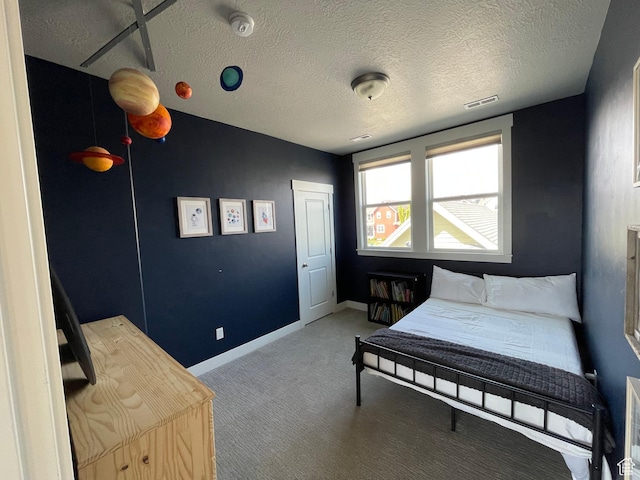 carpeted bedroom featuring a textured ceiling, visible vents, and baseboards