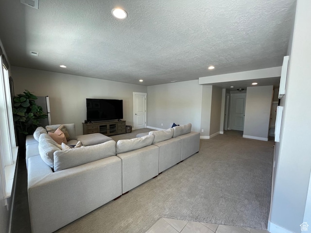 living room with baseboards, a textured ceiling, recessed lighting, and light colored carpet