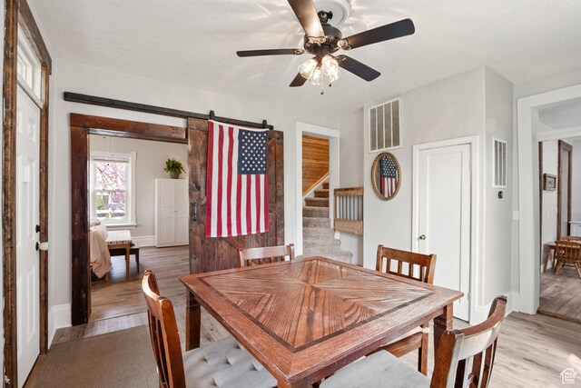 290 N 300 E, Springville, UT 84663 - dining room with light wood finished floors, visible vents, ceiling fan, and a barn door