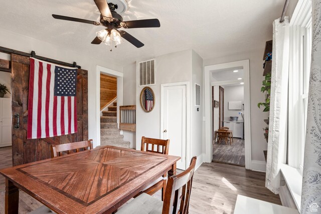 290 N 300 E, Springville, UT 84663 - dining space with a barn door, visible vents, wood finished floors, stairs, and ceiling fan