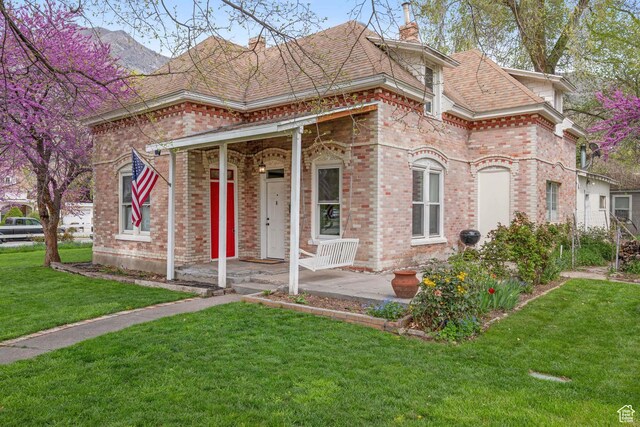 290 N 300 E, Springville, UT 84663 - view of front of house featuring a chimney, brick siding, roof with shingles, and a front yard