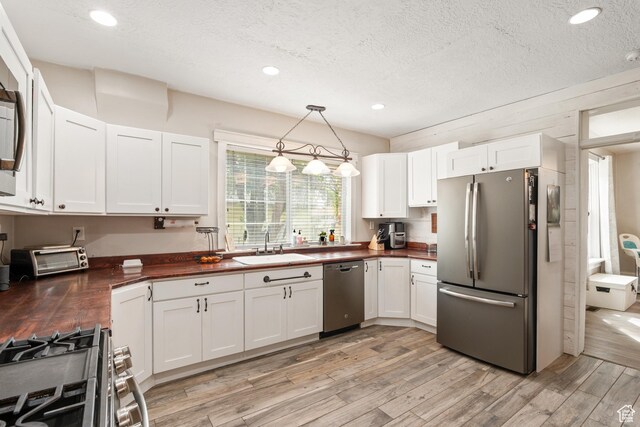 290 N 300 E, Springville, UT 84663 - kitchen with a sink, a toaster, white cabinetry, light wood-style flooring, and appliances with stainless steel finishes